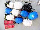 many hard hats, gloves, and gloves laid out on the floor