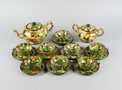 une image représentant un ensemble de théières et de tasses vertes et dorées