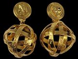 pair of gold earrings with a globe and a coin on top
