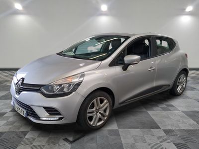 une voiture argentée est garée dans une pièce au sol en damier
