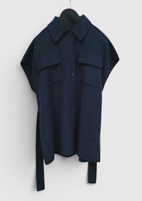 a black shirt hanging on a white wall with a black hanger