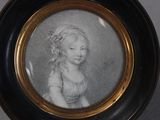 portrait of a young girl in a dress in a black and gold frame