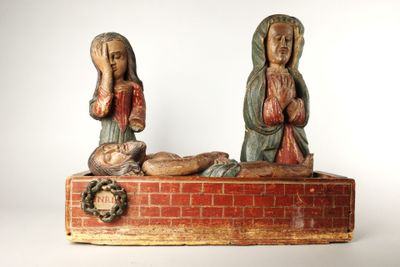 deux statues de Jésus et de Marie assis sur un mur de briques