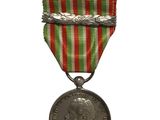 une vieille médaille entourée d'un ruban rouge, blanc et vert