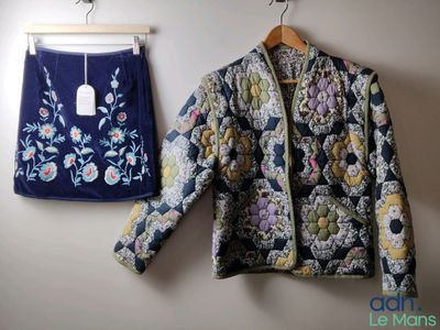 une photo d'une veste et d'une jupe accrochées à un mur