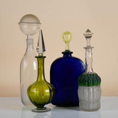 three different colored glass bottles sitting on a table