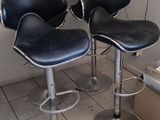 quatre tabourets de bar en cuir noir dans un coin de la pièce
