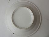 a white plate with a brown rim sitting on a table