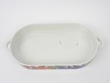a close up of a white rectangular dish with a floral design on it