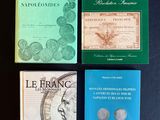 quatre livres posés sur une table noire, sur fond noir