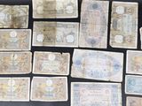 a bunch of old paper money sitting on top of a table