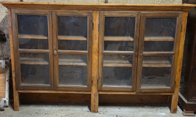 une armoire en bois surmontée de portes vitrées