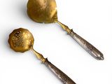 two spoons and a ladet are sitting on a white surface
