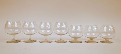 six verres à vin vides alignés sur une surface blanche