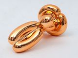 two shiny gold balloons sitting on top of each other on a white surface