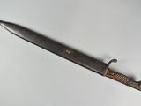 an old knife on a white surface with a black handle
