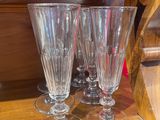 three wine glasses sitting on top of a wooden shelf