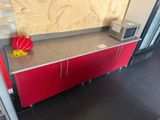 a red cabinet with a microwave on top of it