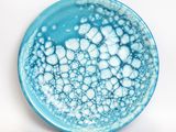 blue and white plate with bubbles on it on a white surface