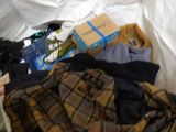 a pile of clothes and a box on a bed