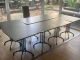 une table et des chaises dans une pièce dotée de grandes fenêtres