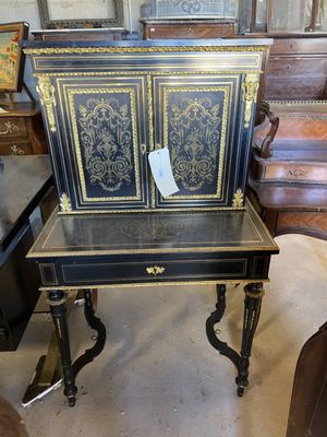 un bureau noir et doré avec une chaise en arrière-plan