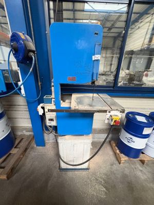 une image représentant une machine bleue dans un entrepôt, entourée de fûts