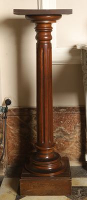 a wooden pedestal with a clock on top of it
