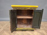 an old wooden cabinet with a yellow top sitting on top of a wooden floor