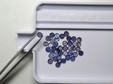 un plateau sur lequel se trouvent quelques pierres bleues et une paire de ciseaux