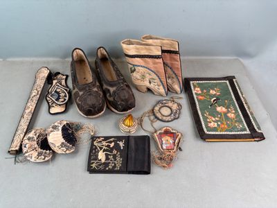 plusieurs paires de chaussures, des sacs à main, des portefeuilles et d'autres objets posés sur une table