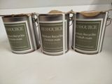 three cans of paint sitting on top of a counter next to each other