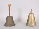 pair of antique brass bells with wooden handle on white background