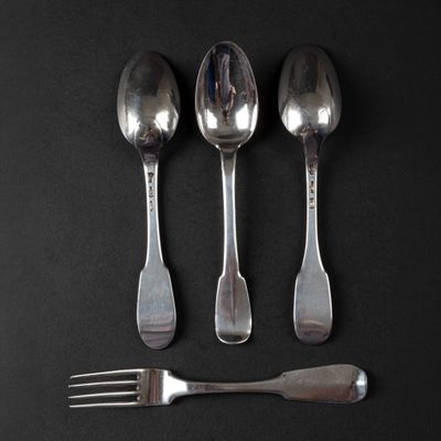 three silver spoons and a fork on a black surface