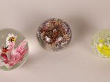 three glass vases with flowers on them sitting on a table