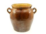 a brown vase with handles sitting on a white surface