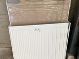 un radiateur blanc posé à côté d'une pile de cartons