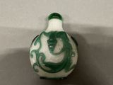 a green and white vase with a dragon on it