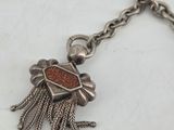 an image of a silver necklace with a red stone in the center