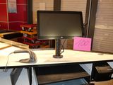 a computer desk with a monitor and a keyboard on it