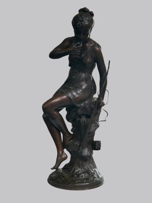 statue d'une femme assise sur un rocher, tenant un fusil