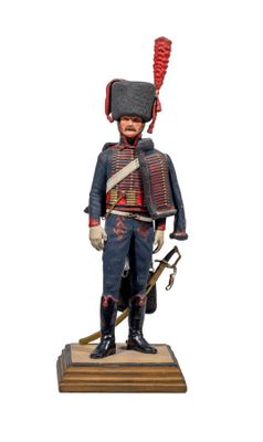 statue of a soldier in uniform with a sword on a wooden base