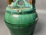 a green pot with two handles on a table