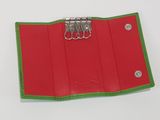 a red and green wallet with a clip on top of it