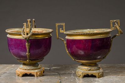 pair of purple and gold vases with handles sitting on a table