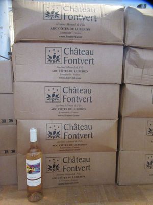 des cartons empilés les uns sur les autres, avec une bouteille de vin posée devant