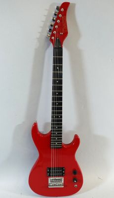 an electric guitar sitting on top of a white surface