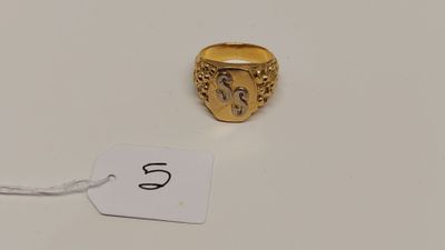 une image d'une bague en or sur une surface blanche avec une étiquette de prix