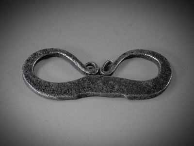 une paire de ciseaux posée sur une table, sur fond gris