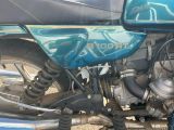 a close up of a blue motorcycle parked on the side of the road